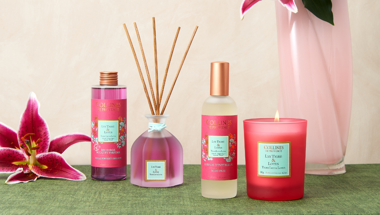 Photo d'une gamme colorée rose comprenant une un bouquet parfumé et sa recharge, un parfum d'intérieur et une bougie allumée