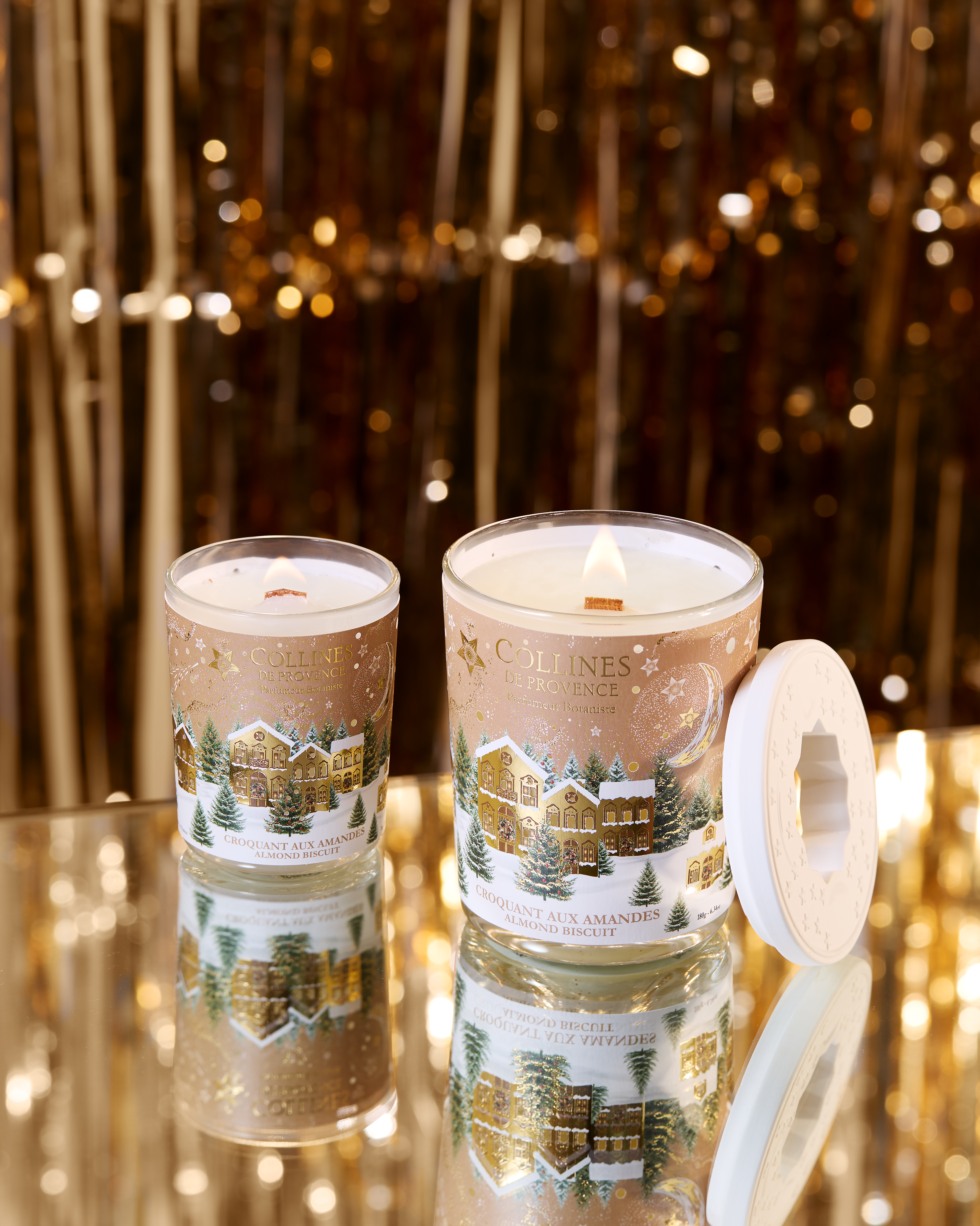 Photo d'une tablée de Noël avec des bougies de différentes couleurs disposées sur une table festive. Sapin de noël  en arrière plan.
