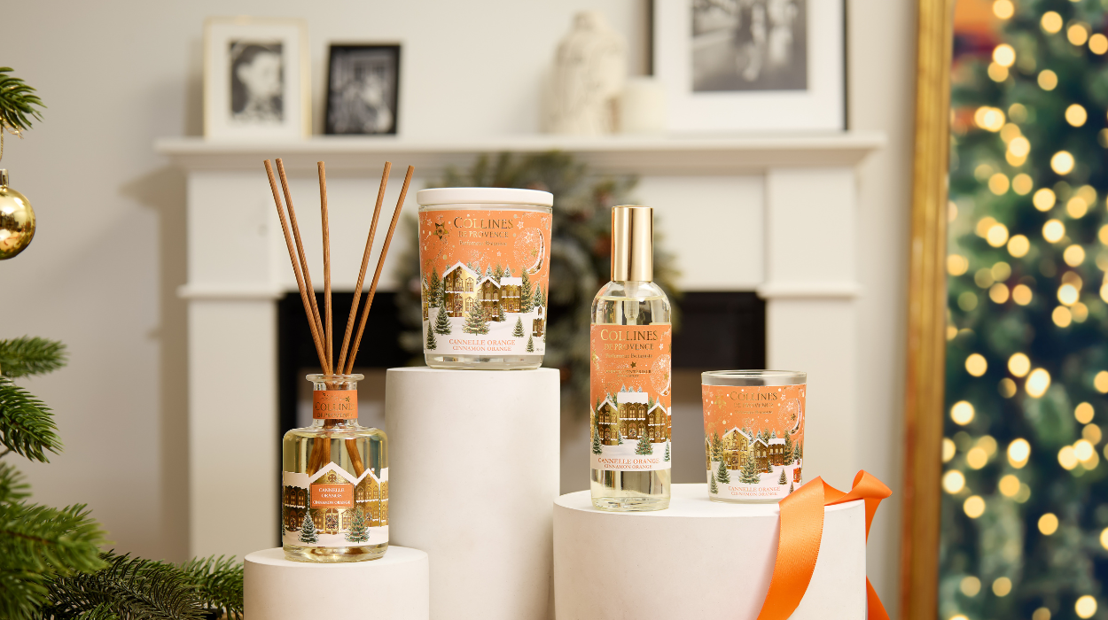 Photo d'une tablée de Noël avec des bougies de différentes couleurs disposées sur une table festive. Sapin de noël  en arrière plan.