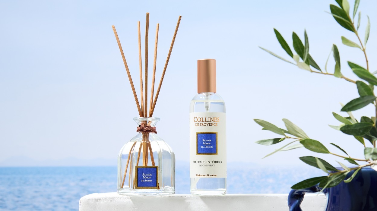 Photo d'une gamme colorée rose comprenant une un bouquet parfumé et sa recharge, un parfum d'intérieur et une bougie allumée