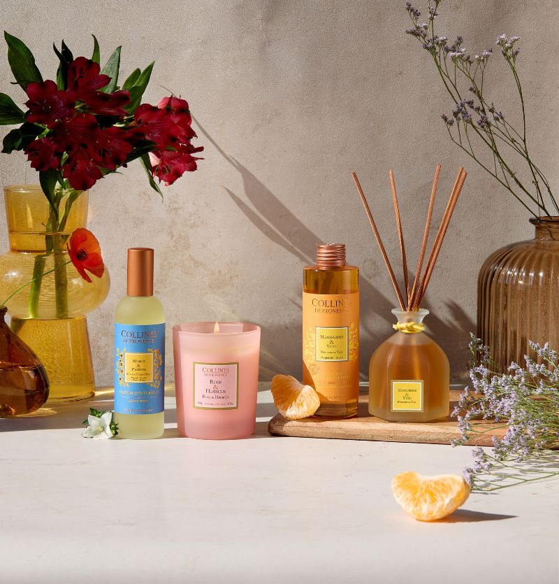Produits parfumés Collines de Provence avec fleurs, lavande et mandarine dans une ambiance naturelle.